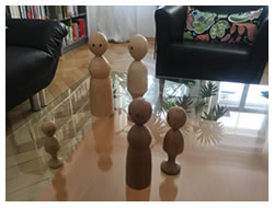 Foto Glastisch mit Holzfiguren in unterschiedlichen Größen
